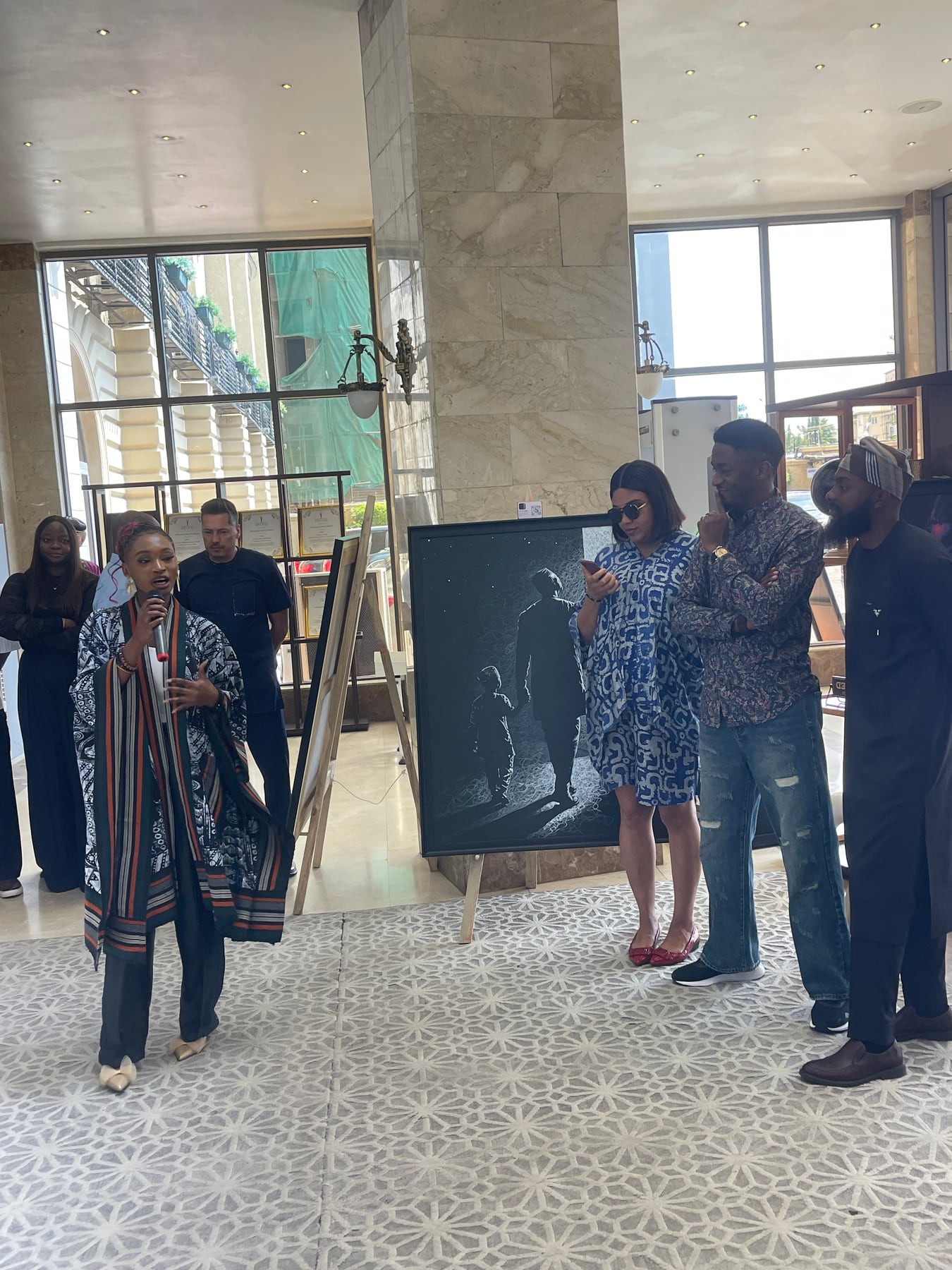 Speaking to guests beside a work during the opening.