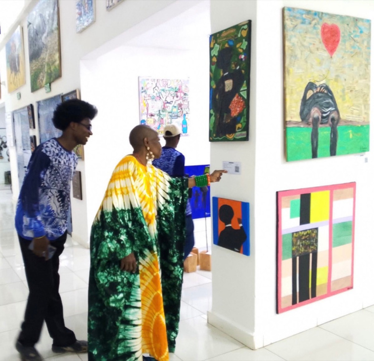 Two visitors in conversation in front of the exhibited works